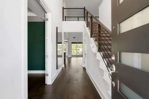 a view of entryway and hall with wooden floor