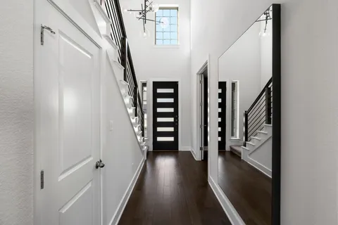 a view of a hallway with wooden floor and stairs