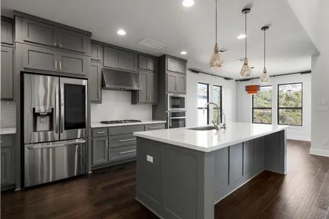 a kitchen with stainless steel appliances granite countertop a sink stove and refrigerator