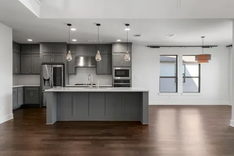 a kitchen with stainless steel appliances granite countertop a stove a sink and a refrigerator