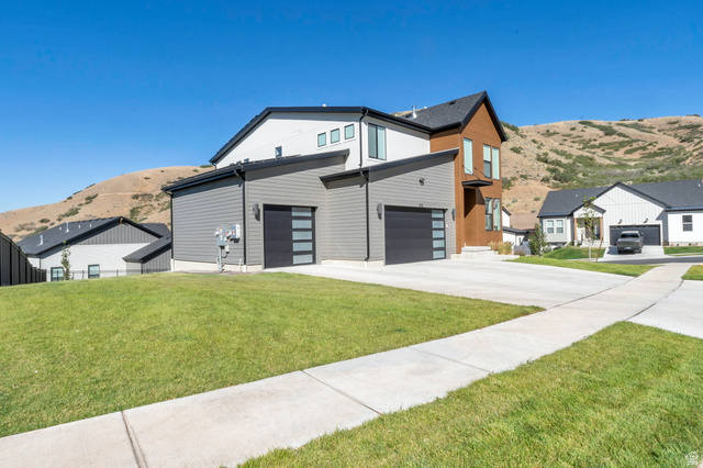 1711 West Canyon Rim Road North Lehi, UT 84048 - Photo 3 of 31 Contemporary architecture featuring a multi-tone exterior, attached two-car garage with modern doors, and a concrete driveway