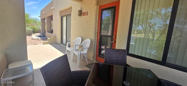 a view of a balcony dining area with furniture and window