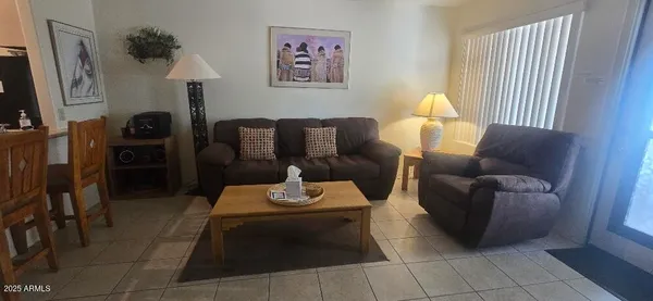 a living room with furniture a flat screen tv and a window