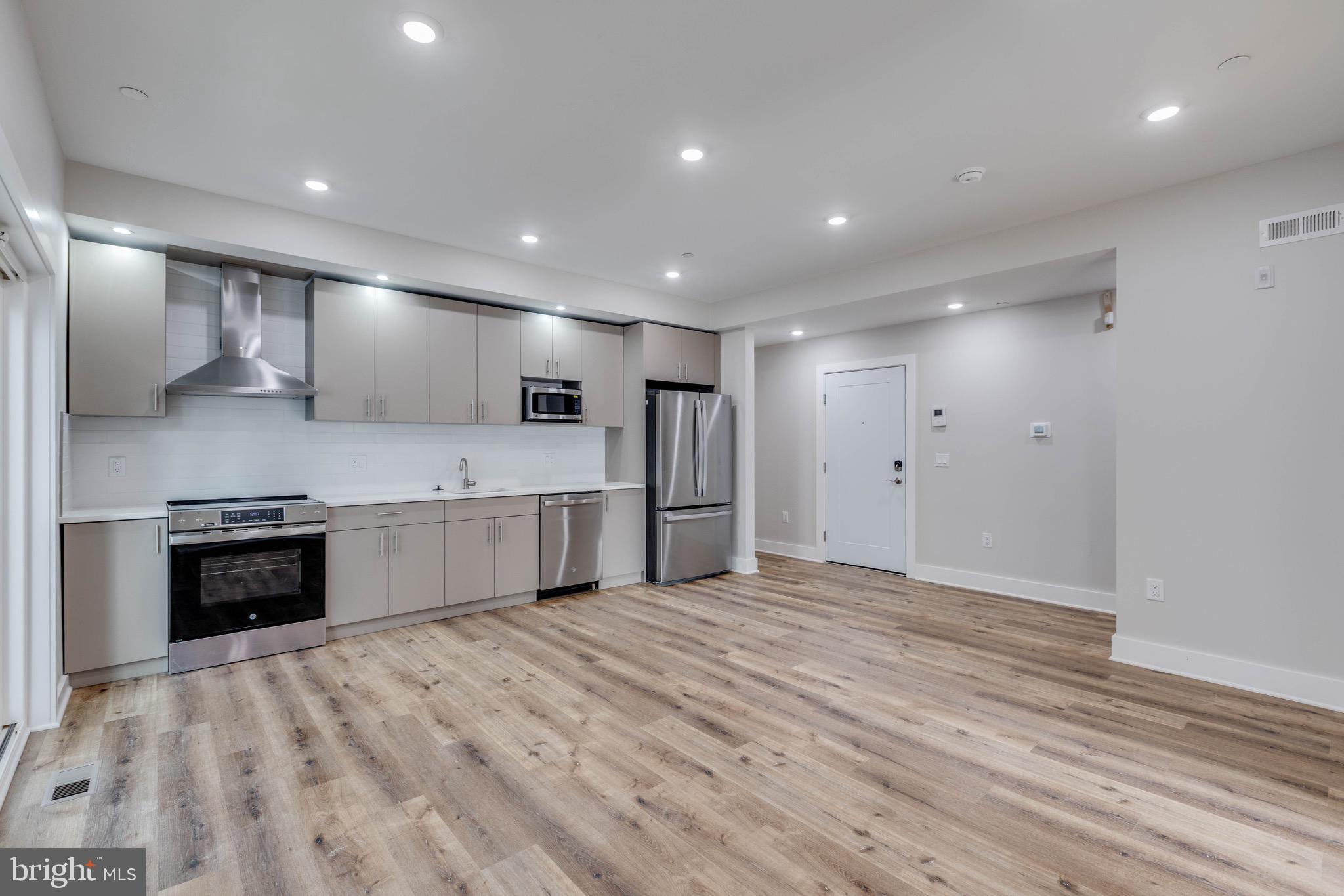 1434 Parrish Street, Unit B Philadelphia, PA 19130 - Photo 16 of 17 a large kitchen with stainless steel appliances granite countertop a large counter top a stove and a sink