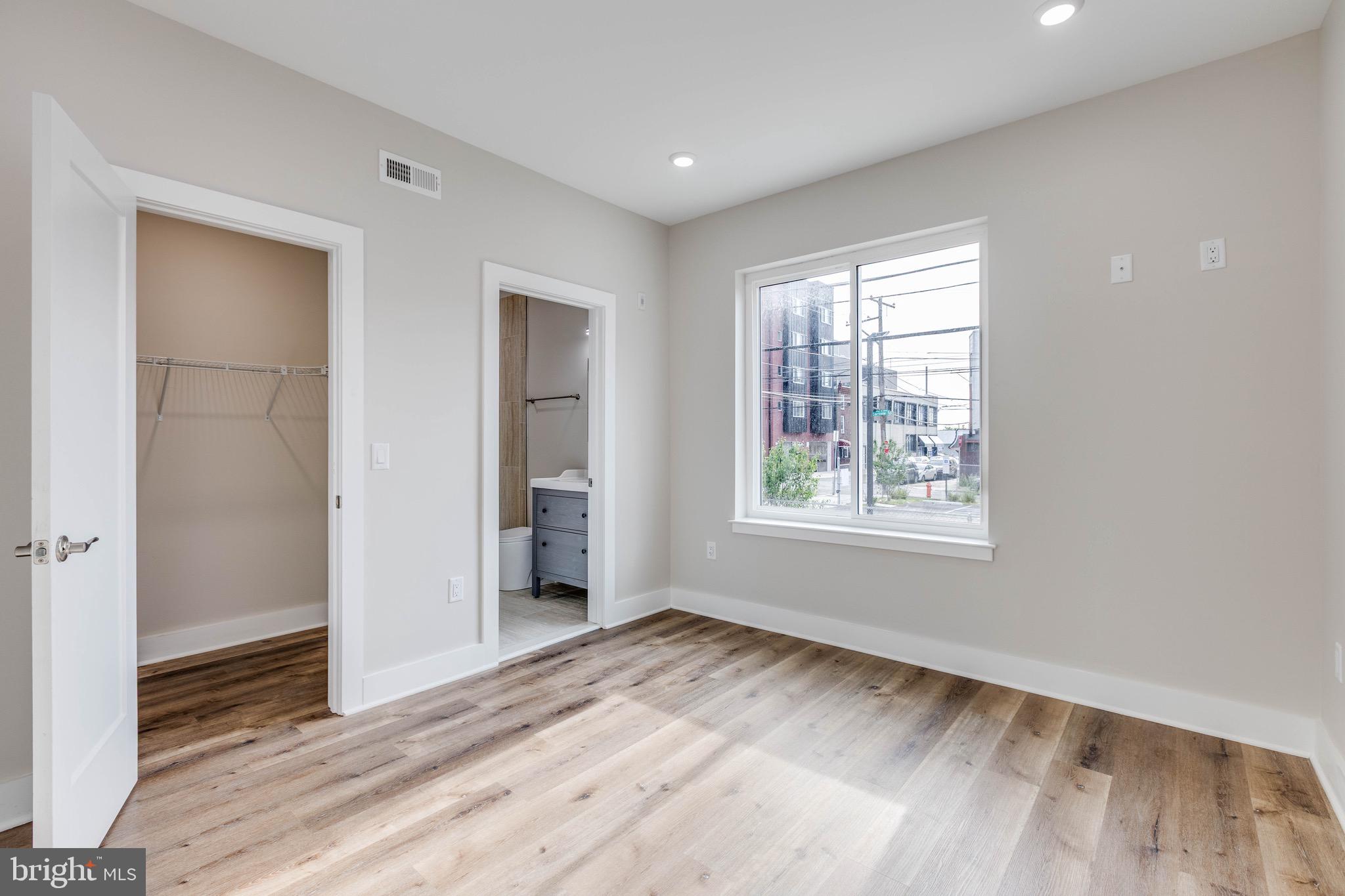 1434 Parrish Street, Unit B Philadelphia, PA 19130 - Photo 8 of 17 a view of an empty room with wooden floor and a window