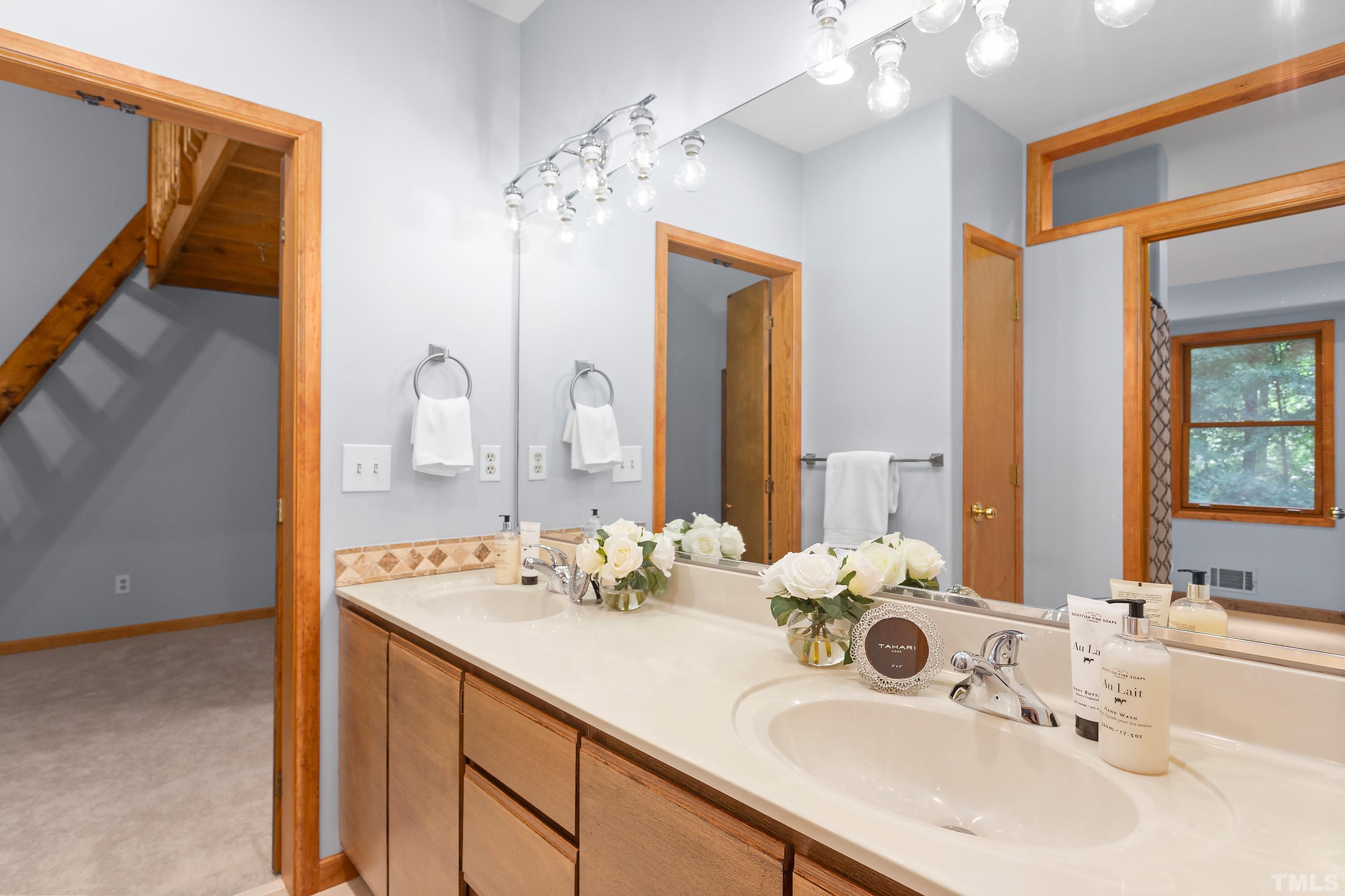 2600 Ferrand Drive Durham, NC 27705 - Photo 23 of 67 a bathroom with a double vanity sink and a mirror