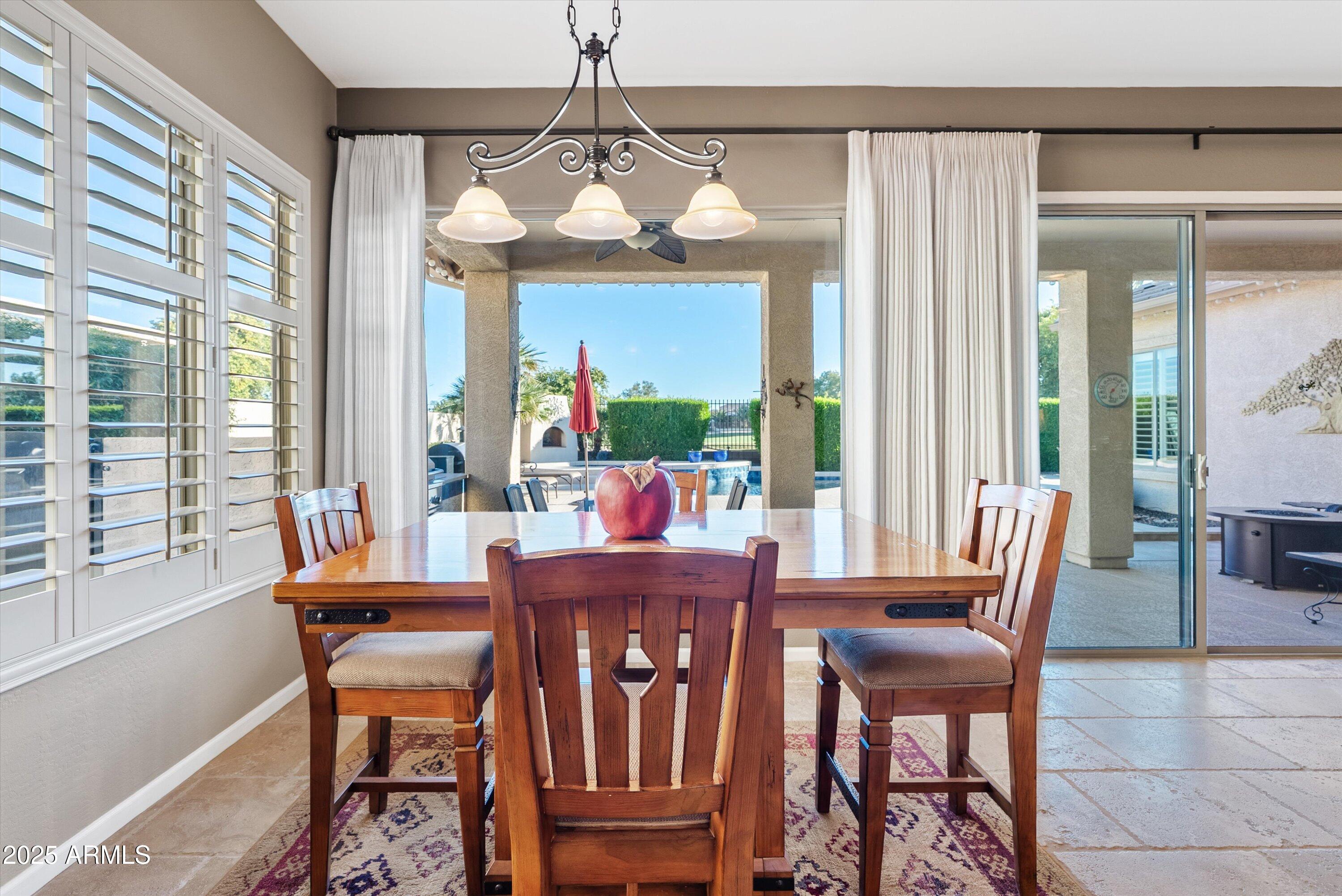 6805 Rachael Way Gilbert, AZ 85298 - Photo 14 of 50 a view of a dining room with furniture wooden floor and chandelier