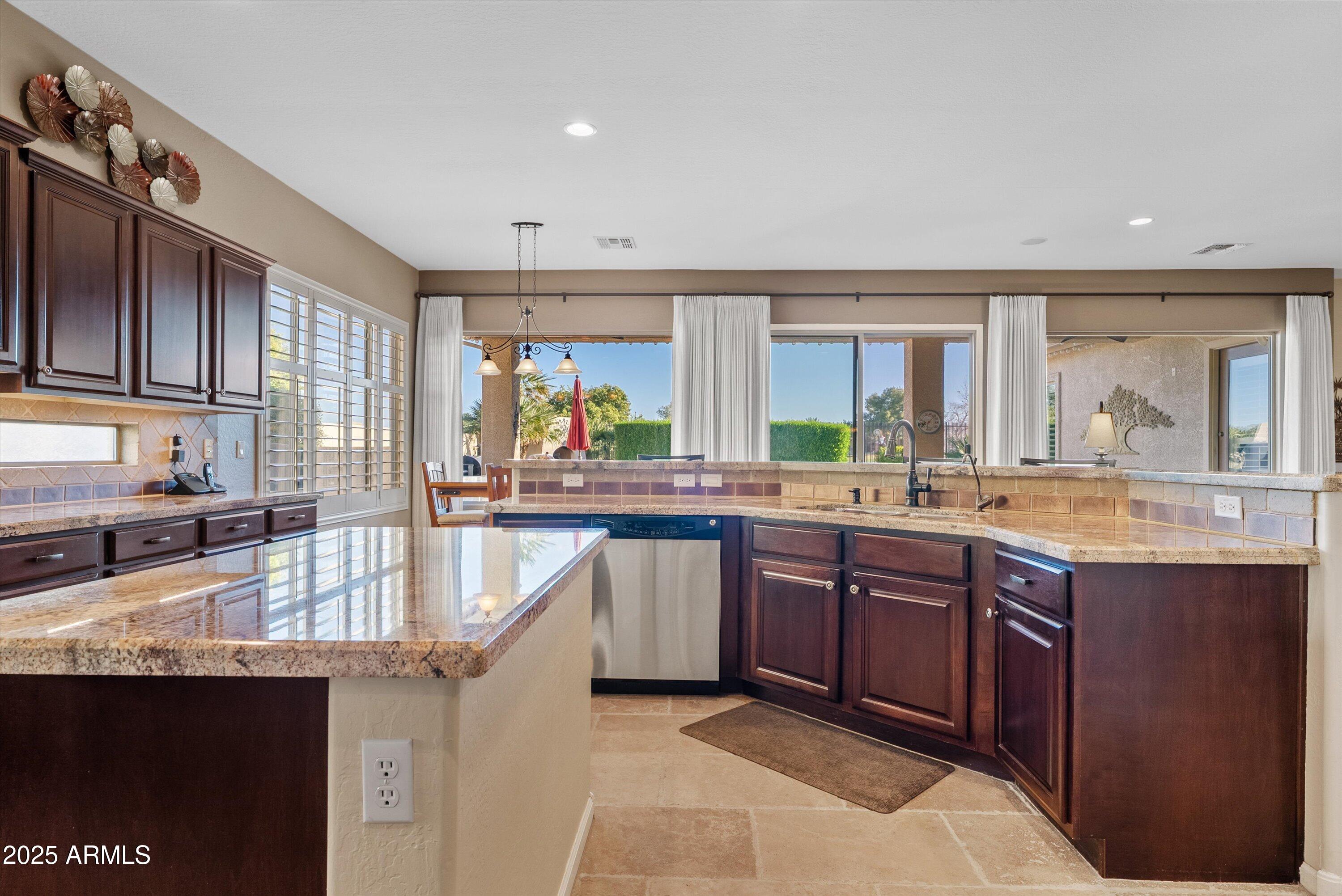 6805 Rachael Way Gilbert, AZ 85298 - Photo 16 of 50 a kitchen with granite countertop a sink stove and cabinets