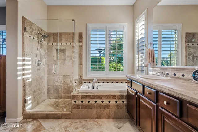 a spacious bathroom with a granite countertop bathtub a sink and a large mirror