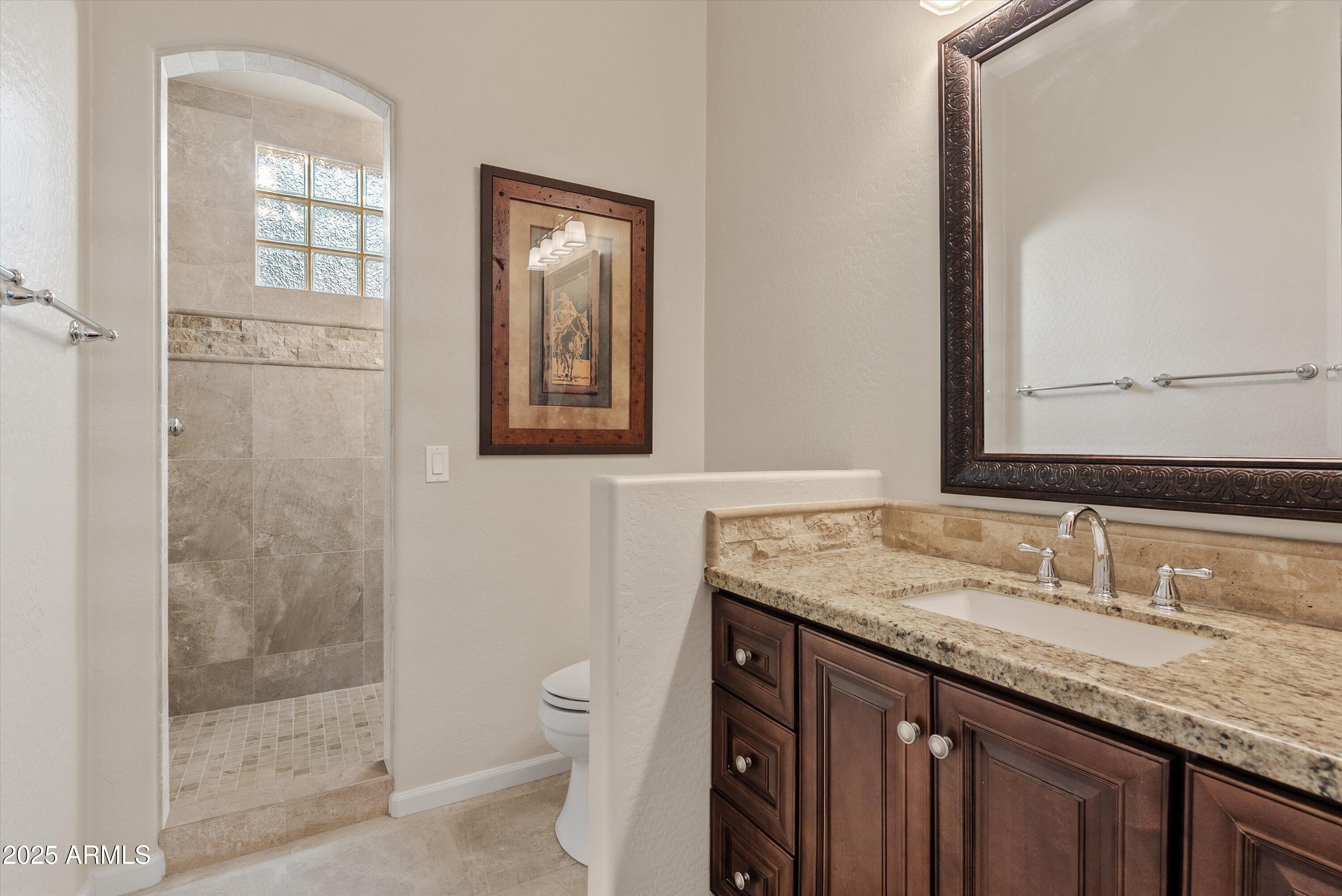 6805 Rachael Way Gilbert, AZ 85298 - Photo 30 of 50 a bathroom with a granite countertop sink a mirror and a shower