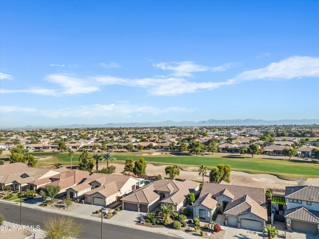 an aerial view of a city with lots of residential buildings ocean and mountain view in back