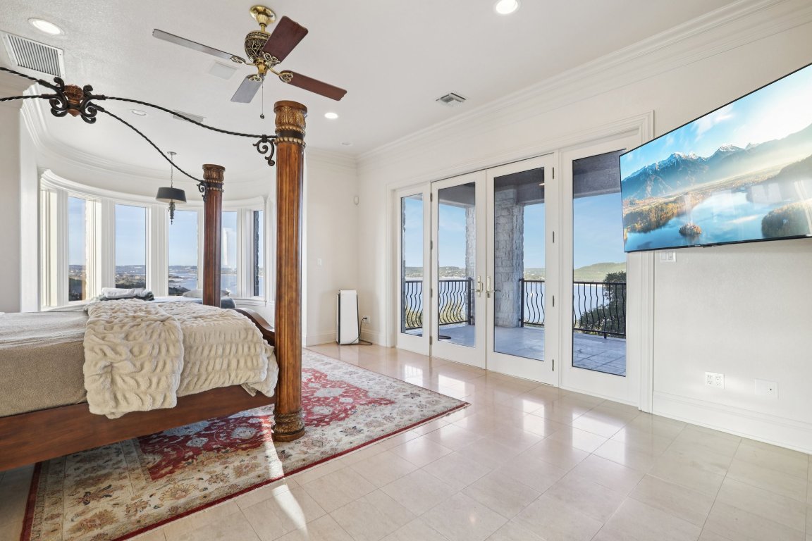 14701 Hornsby Hill Road Austin, TX 78734 - Photo 23 of 40 a spacious bedroom with a bed and a chandelier