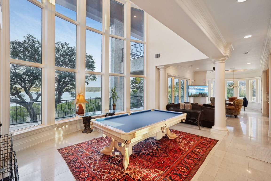 14701 Hornsby Hill Road Austin, TX 78734 - Photo 10 of 40 a living room with a rug floor to ceiling window and wooden floor