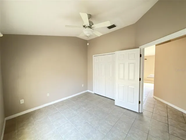 an empty room with a ceiling fan and a window