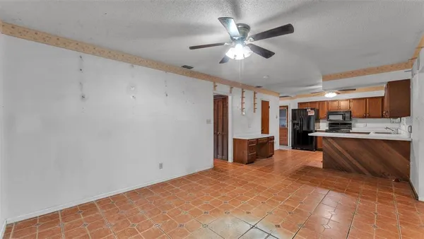 a large white kitchen with a large window stainless steel appliances and cabinets