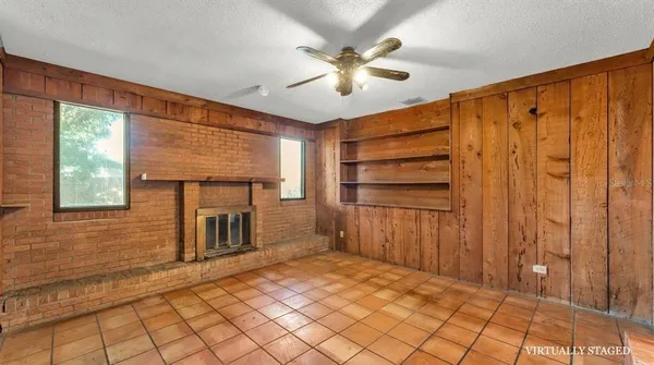 a view of a livingroom with a chandelier fan and windows