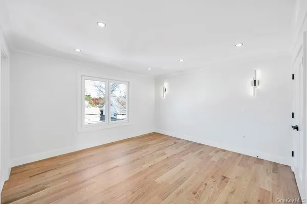 an empty room with wooden floor and window