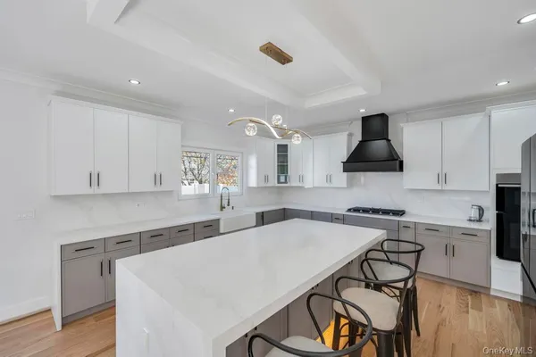 a kitchen with stainless steel appliances a sink a stove a table and chairs