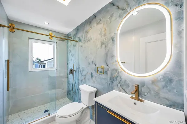 a bathroom with a sink a toilet and shower