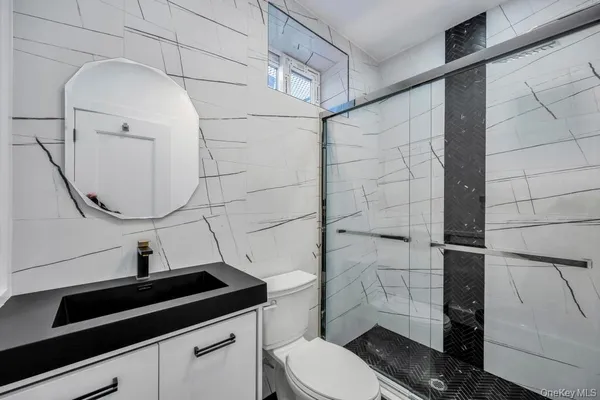 a bathroom with a sink a toilet and shower