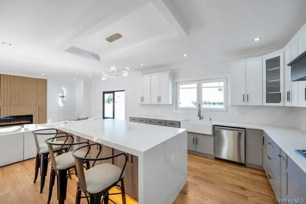 a kitchen with stainless steel appliances granite countertop a stove top oven a sink dishwasher a dining table and chairs with wooden floor