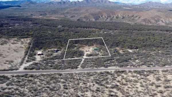 a view of a house with small yard plants and wooden fence