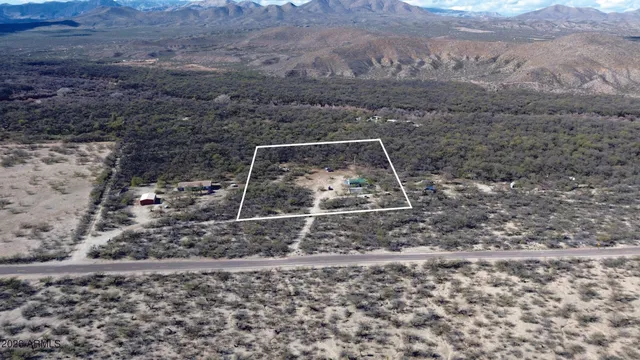 a view of a house with small yard plants and wooden fence