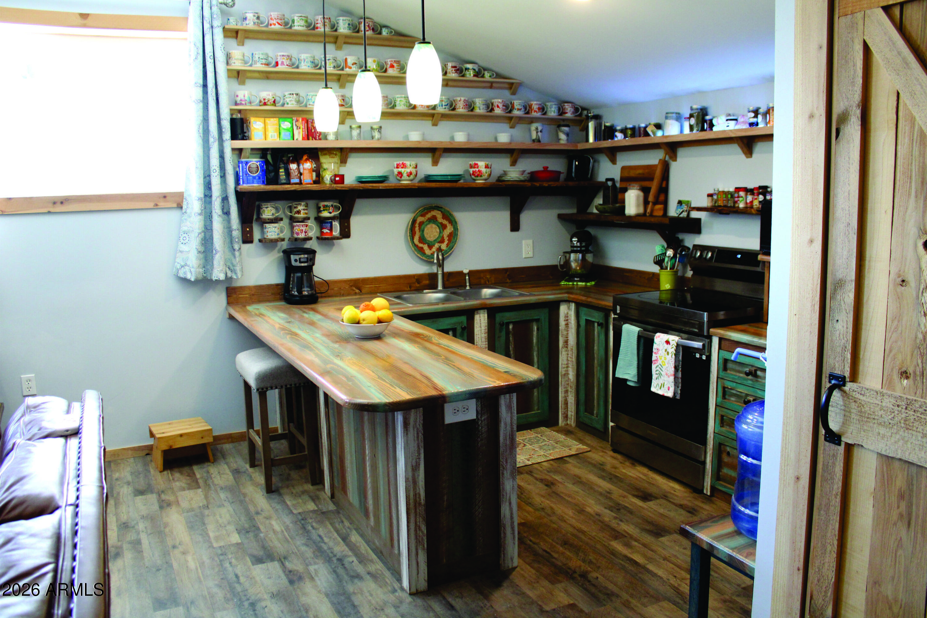 3236 North Cascabel Road Benson, AZ 85602 - Photo 7 of 63 a view of a room with shelves and wooden floor
