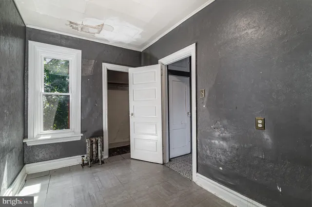 an empty room with windows and closet