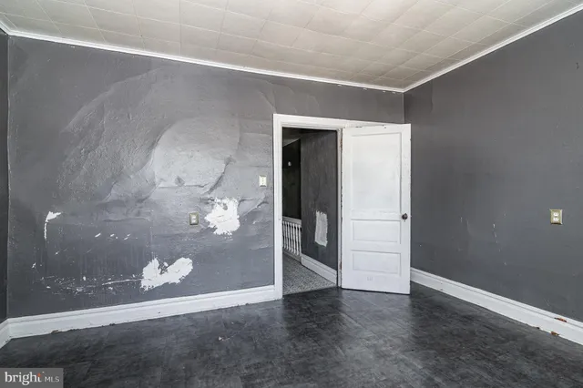 an empty room with wooden floor and door