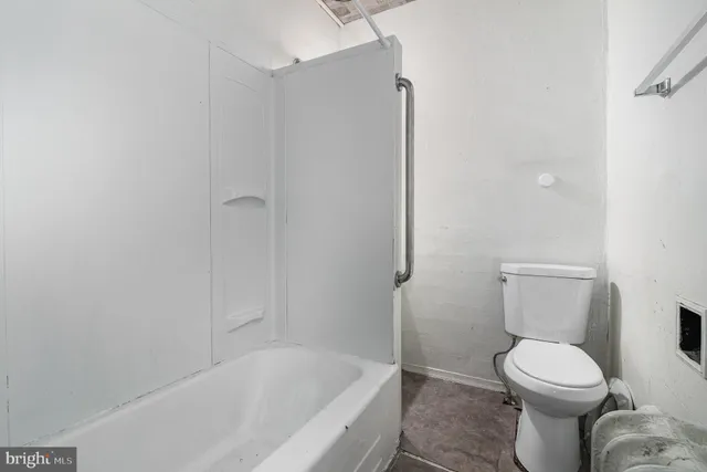 a white toilet sitting next to a bathtub