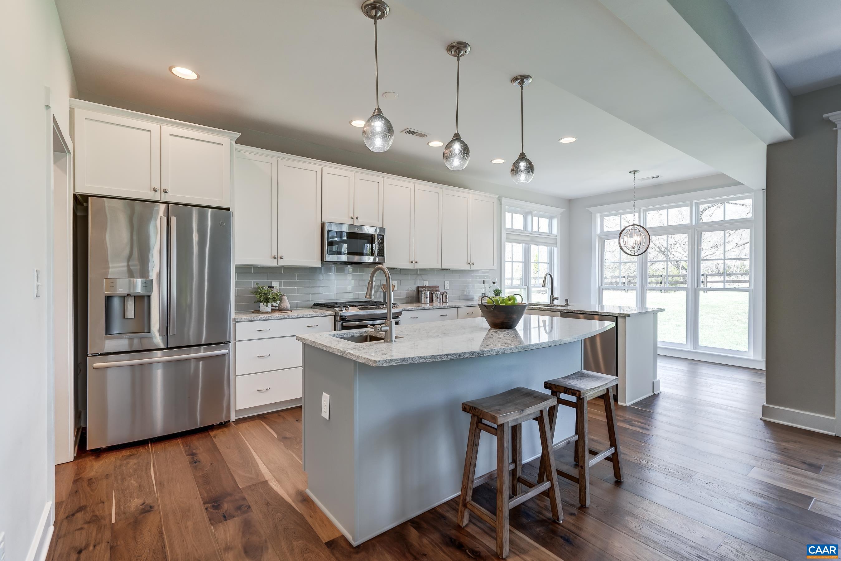 7659 Birchwood Hill Road Crozet, VA 22932 - Photo 11 of 64 a kitchen with stainless steel appliances a refrigerator a stove a sink a dining table and chairs with wooden floor