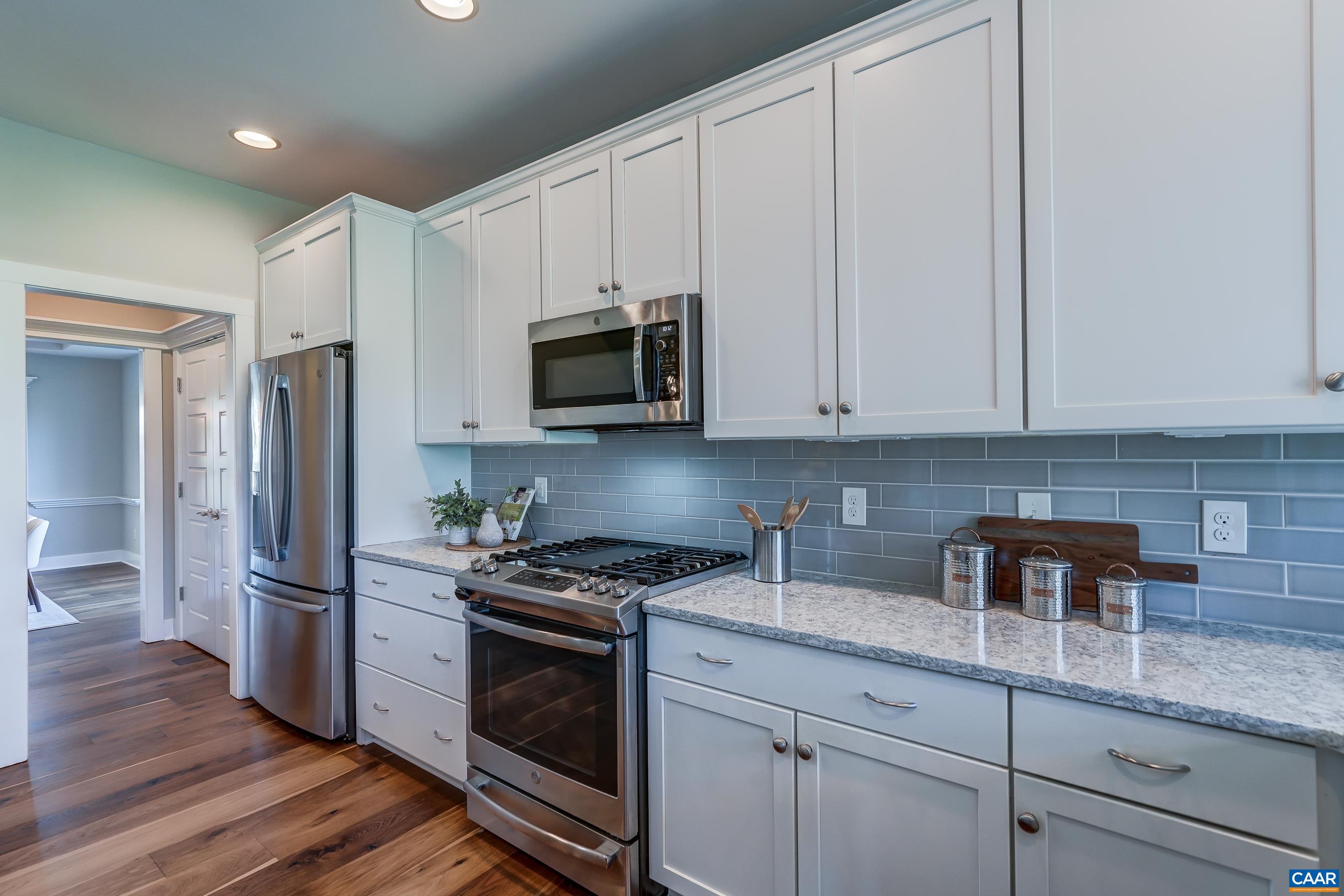 7659 Birchwood Hill Road Crozet, VA 22932 - Photo 16 of 64 a kitchen with granite countertop white cabinets stainless steel appliances and wooden floor