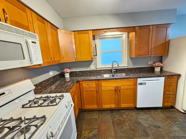 a kitchen with stainless steel appliances granite countertop a stove a sink and a microwave