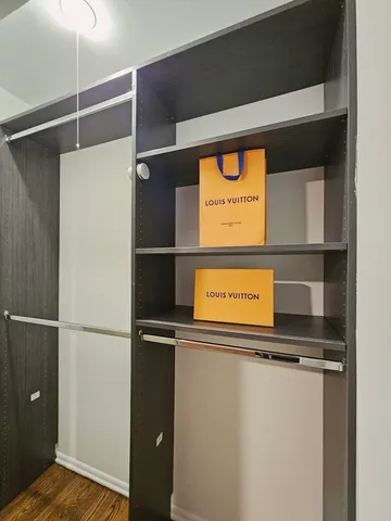 a view of a room with wooden floor and a ceiling fan
