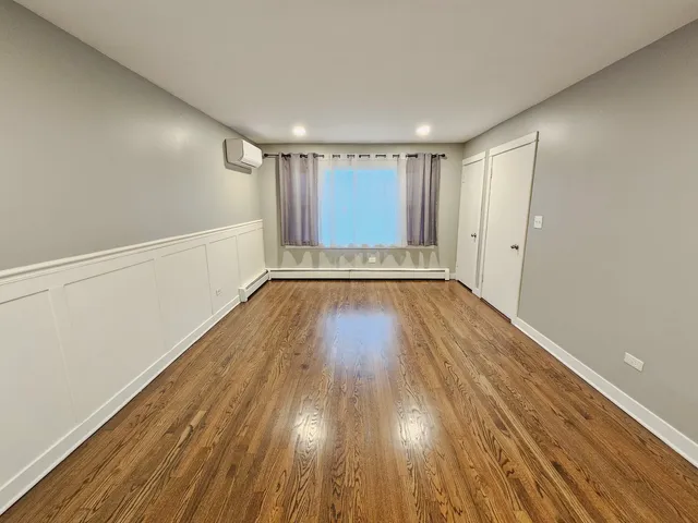 a view of an empty room with wooden floor