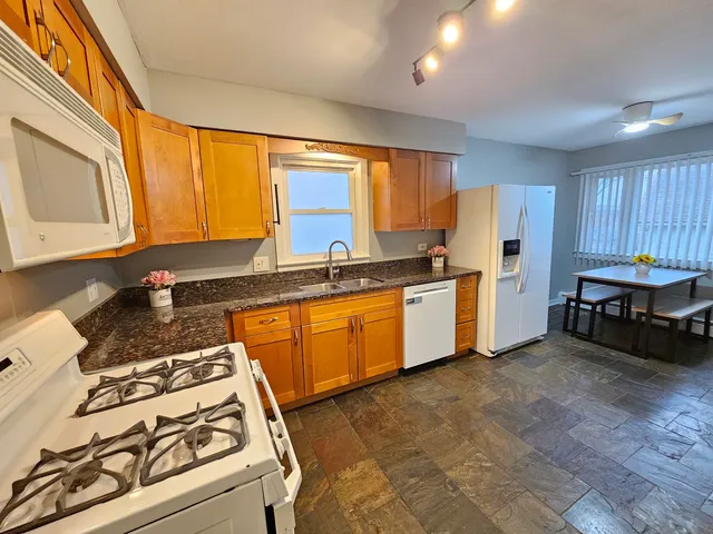 a kitchen with stainless steel appliances granite countertop a stove a sink and a refrigerator