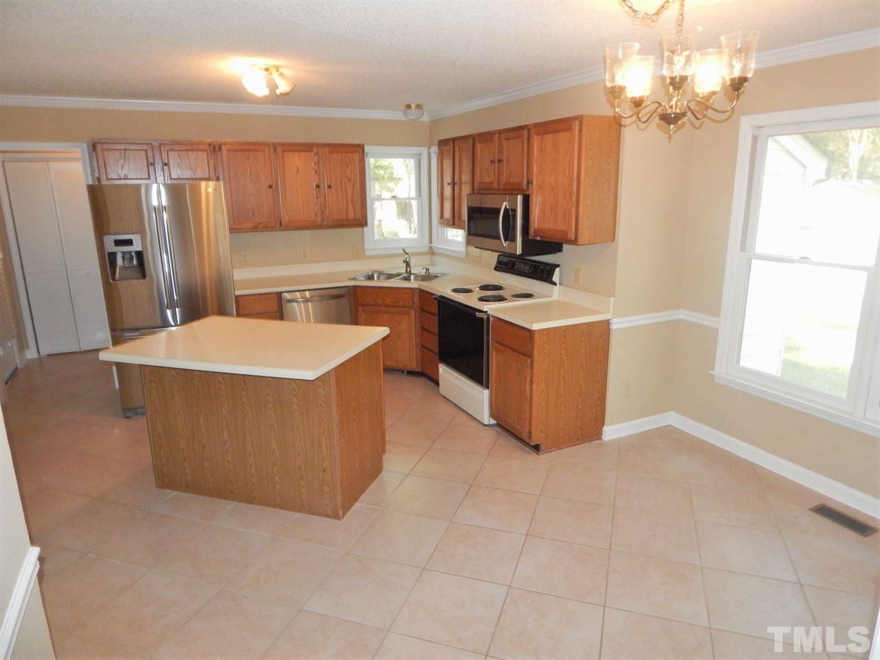 4829 Draper Road Raleigh, NC 27616 - Photo 3 of 25 a kitchen with stainless steel appliances a sink a stove a refrigerator cabinets and a window