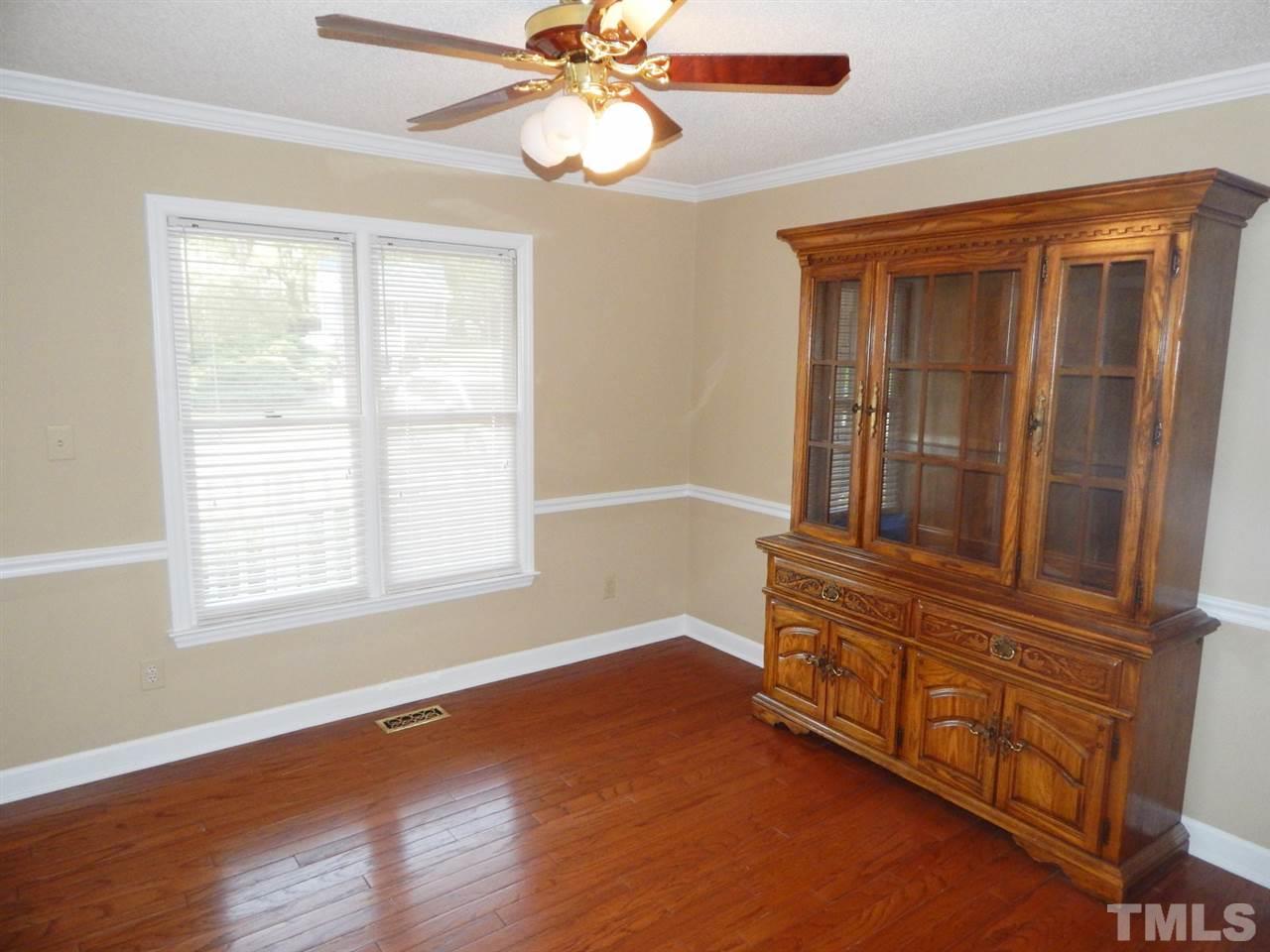 4829 Draper Road Raleigh, NC 27616 - Photo 5 of 25 a view of an empty room with wooden floor and a window