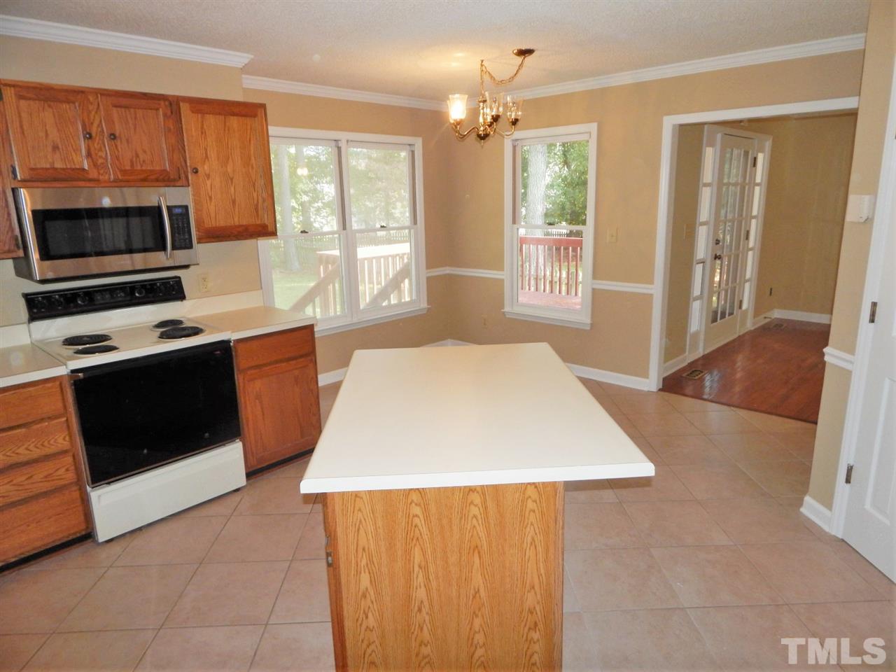 4829 Draper Road Raleigh, NC 27616 - Photo 9 of 25 a kitchen with wooden cabinets a sink a stove and a oven