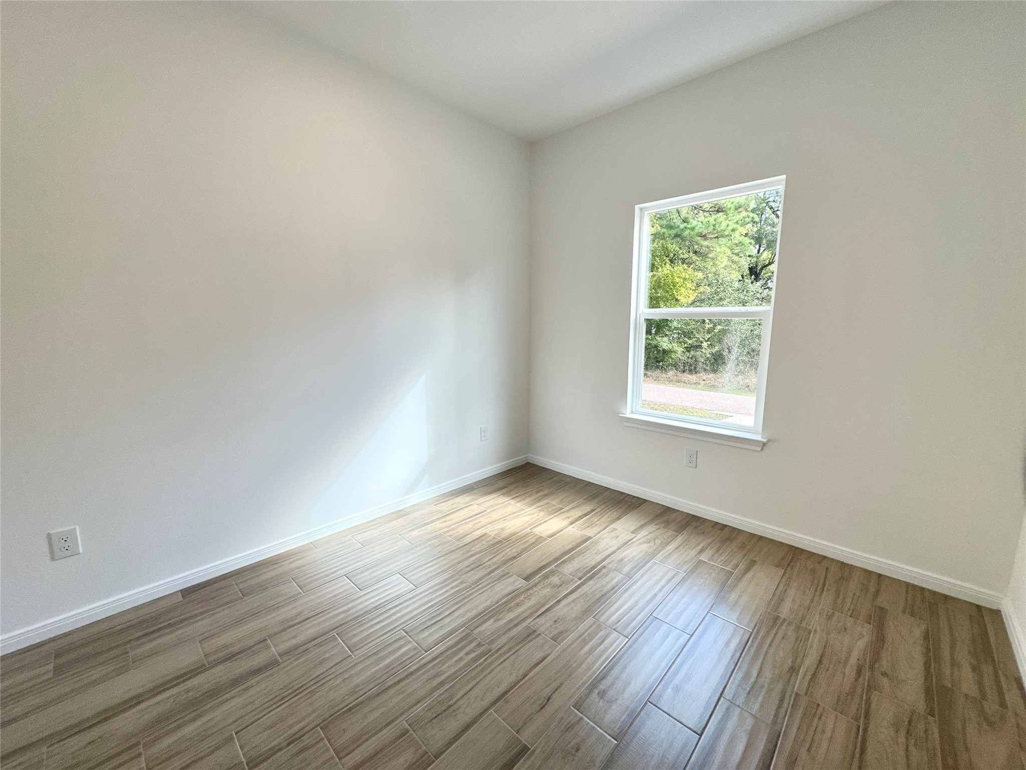 11563 Persimmon Street Willis, TX 77318 - Photo 19 of 19 an empty room with wooden floor and windows