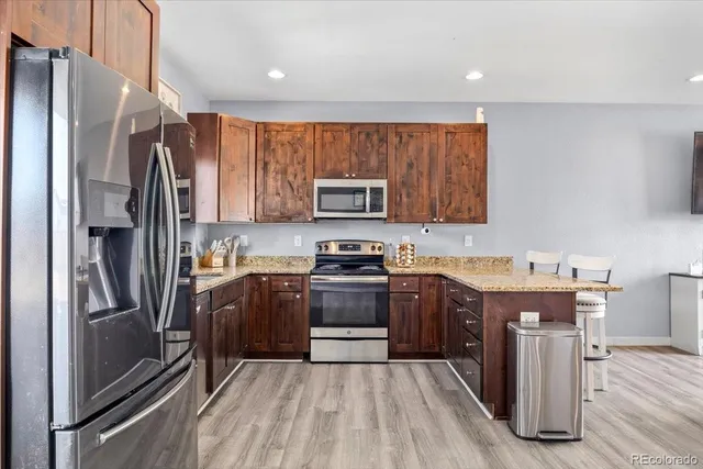 a kitchen with stainless steel appliances granite countertop a refrigerator stove and sink