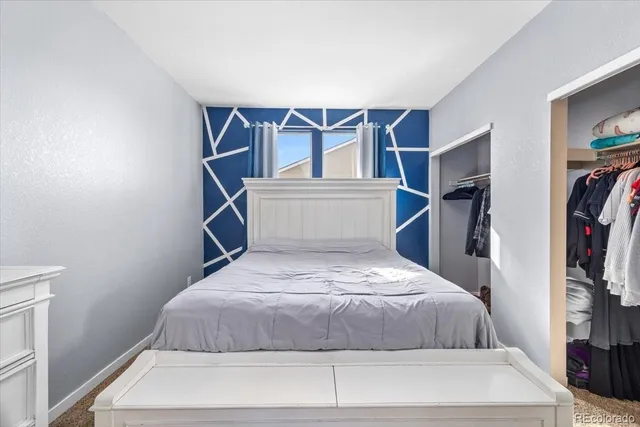 a bedroom with a bed and a flat tv screen on the dresser