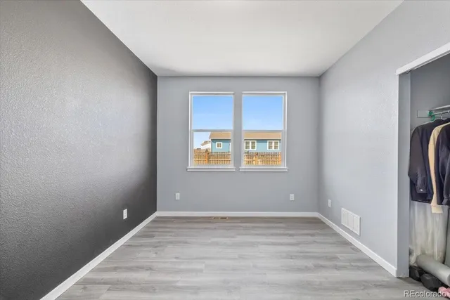 a view of empty room with window and wooden floor