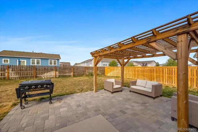 a backyard of a house with barbeque oven table and chairs