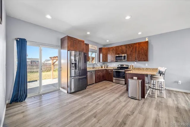 a kitchen with stainless steel appliances a refrigerator sink and wooden cabinets