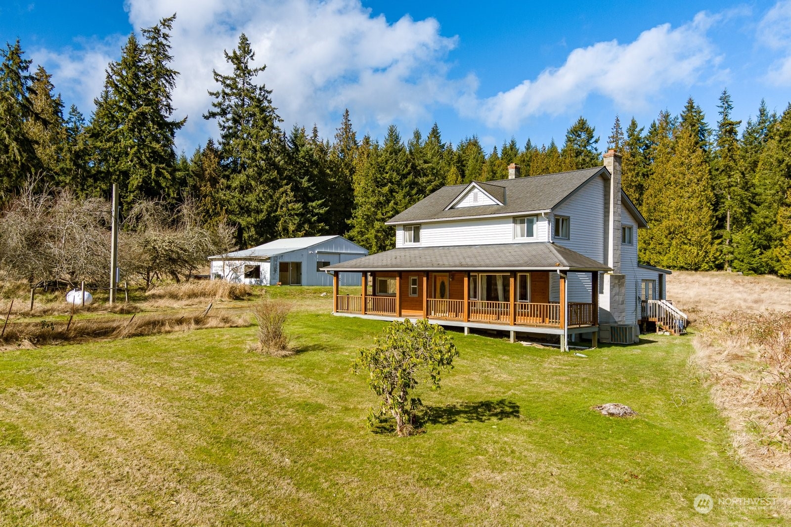 a view of a house with a big yard and large trees