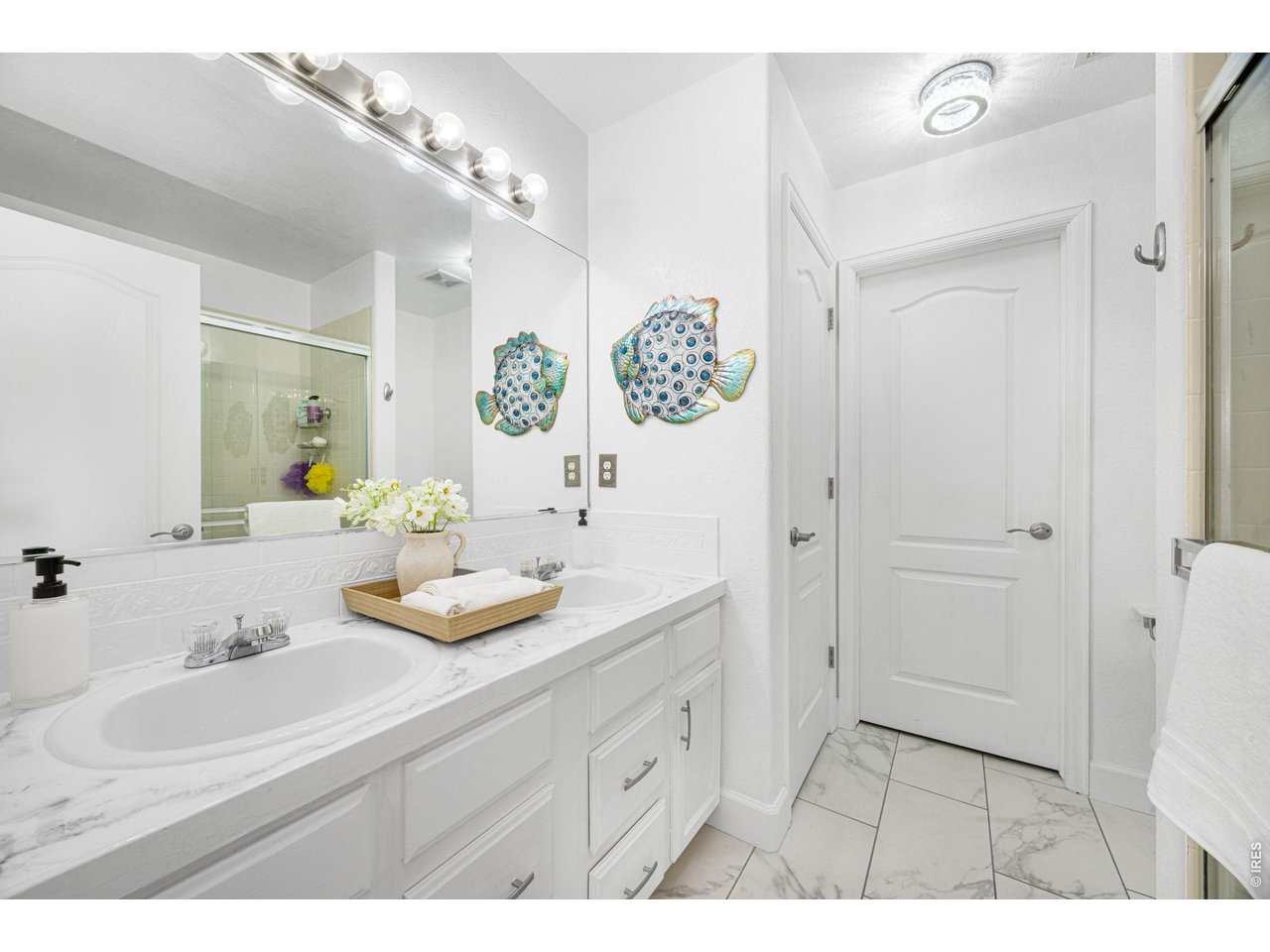 148 Beacon Way Windsor, CO 80550 - Photo 22 of 36 Primary bathroom with dual sink vanity, updated countertops, ample cabinet storage, and newer tile flooring.