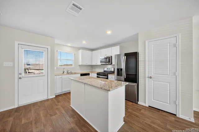 a kitchen with white cabinets and white appliances