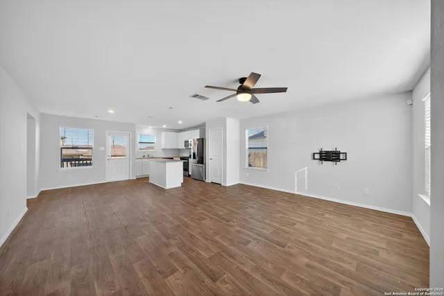 a view of empty room with wooden floor and window